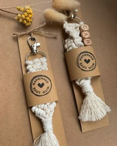 two key chains with tassels on them sitting next to each other in front of a string