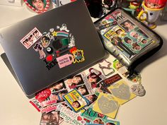 a laptop computer sitting on top of a table covered in stickers and magnets