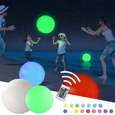 several people are playing with glowing balls on the beach at night, and one person is holding a cell phone