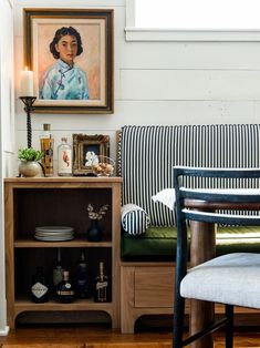 a living room filled with furniture and a painting hanging on the wall above a table