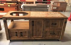 a kitchen island made out of wood with granite top and drawers on casteors in a store