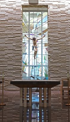 a stained glass window in the center of a room with wooden chairs and a table