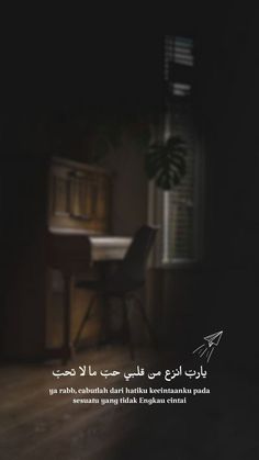 a dark room with a table and chair in it, the words written in arabic