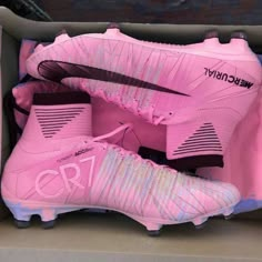 a pair of pink soccer cleats in a box