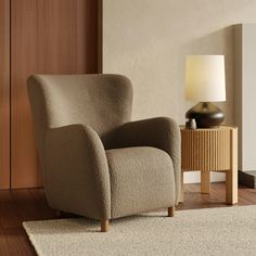 a chair sitting on top of a wooden floor next to a lamp