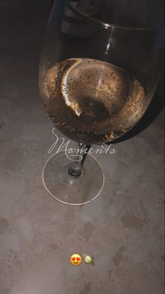 a wine glass filled with liquid sitting on top of a table