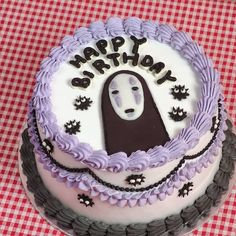 a birthday cake with a ghost face on the top and purple icing around it