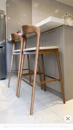 two wooden stools sitting next to each other in a kitchen