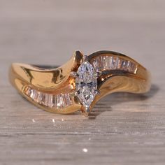 a close up of a diamond ring on a wooden surface