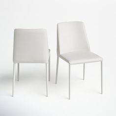 two white chairs sitting next to each other on a white surface with no one in it