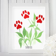 a red and green flower is in front of a white frame with the number 2052 on it