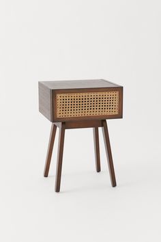 the side table is made out of wood and has a rattan pattern on it