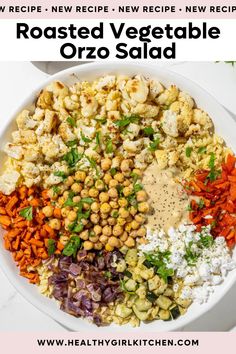 a white bowl filled with roasted veggies, cauliflower, carrots and chickpeas