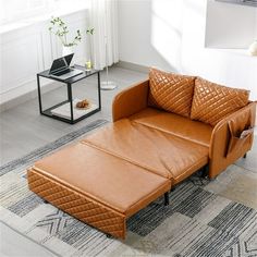 a brown leather couch sitting on top of a rug