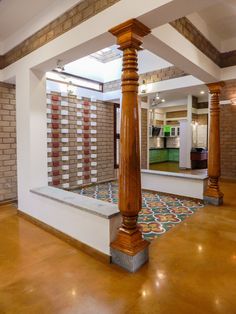 the inside of a house with wooden pillars and tile flooring on either side of it