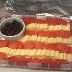 an american flag shaped platter with cheese, crackers and olives on it