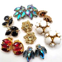 several different colored and shaped brooches on a white surface