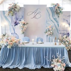 the table is set up with blue cloths and floral centerpieces on it