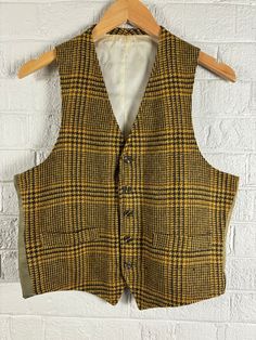 Vintage 1960's Glen Plaid Wool Blend Vest Waist Coat. Men's medium. Brown and Gold Plaid Wool Front with Olive Green Nylon Back and Ivory Inner Lining. In Good Vintage Condition with some Fading on the outer Back Shell and some discoloration on the inner shell. All due to age and sunlight. Vest has two lined pockets on the front. If you have any questions, please don't hesitate to ask!  Thank You Tailored Vintage Cotton Outerwear, Tailored Vintage Winter Vest, Vintage Winter Vest With Button Closure, Vintage Fall Vest With Buttons, Vintage Wool Vest For Fall, Tailored Vintage Fall Vest, Vintage Workwear Vest With Pockets, Vintage Vest With Pockets For Work, Tailored Vintage Wool Vest