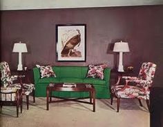 a living room with green couches and chairs in front of a painting on the wall