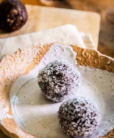 three chocolate truffles on a white plate