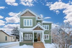 a house with snow on the ground and stairs leading up to it's front door