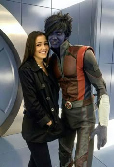 a woman standing next to a man dressed as star trek cosplay in front of a wall