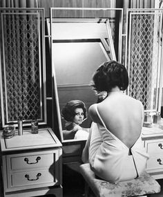 a woman looking at herself in the mirror