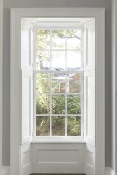 an empty room with white walls and windows