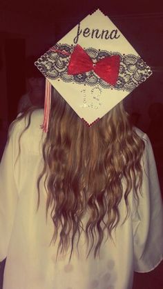 a girl with long hair wearing a graduation cap that says jenny on the front and has a red bow at the top