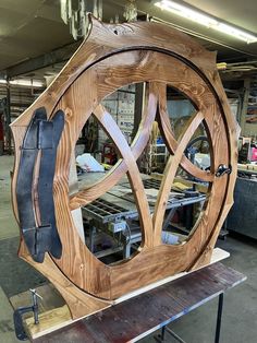 a large wooden clock sitting on top of a table next to a metal workbench