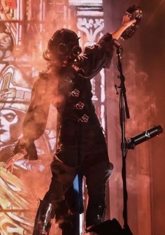 a man standing on top of a stage with his arms out in front of him