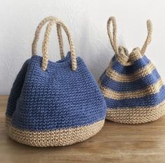 two blue and white baskets sitting on top of a wooden table next to each other