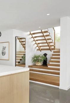 a kitchen with white walls and wooden stairs