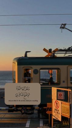 a train traveling down tracks next to the ocean at sunset with people sitting on it