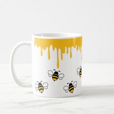 a yellow and white coffee mug with bees on it