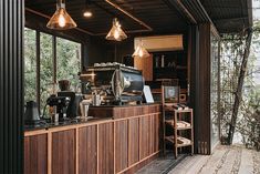 an outdoor bar with lots of lights hanging from it's ceiling and wooden shelves