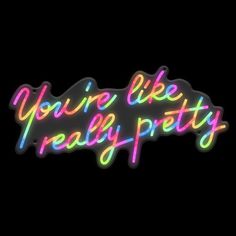 the words you're like really pretty are lit up in neon colors on a black background