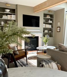 a living room filled with furniture and a flat screen tv mounted on the wall above a fire place