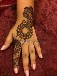 a woman's hand with henna tattoos on it