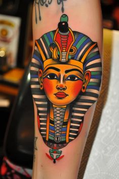 an egyptian tattoo on the leg of a woman's arm, showing her face and head