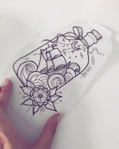 a hand holding a piece of paper with a drawing on it that says ship in a bottle