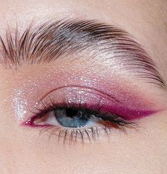 a woman's eye with pink and silver glitters on her eyeshade