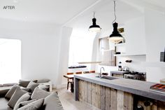 an open kitchen and living room are shown in this modern style home with white walls