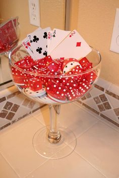 a glass bowl filled with playing cards on top of a counter