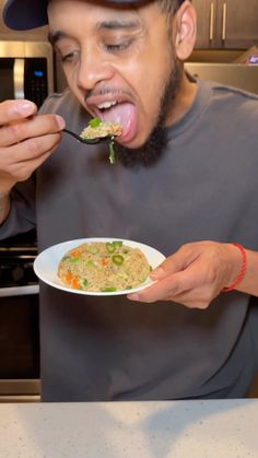 a man eating food out of a white plate