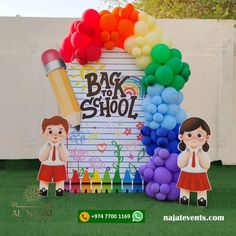 the back to school sign is made out of balloons and paper cutouts, while two children stand in front of it