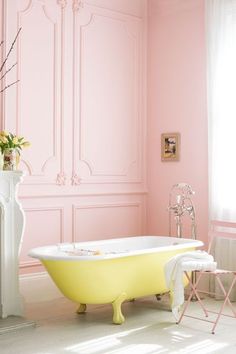 a pink bath tub sitting next to a white fireplace