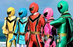 the power rangers are standing in front of the ocean