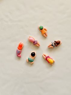 several small toy figures laying on top of a white surface